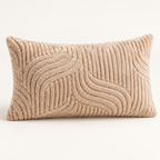 A rectangular lumbar throw pillow in a textured beige bouclé fabric with a raised wavy pattern, shown against a plain off-white background.