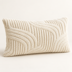 A rectangular lumbar throw pillow in cream with a textured, raised wavy pattern, shown on a neutral light beige background.