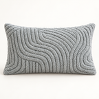 A rectangular lumbar throw pillow in a textured, chunky knit fabric with a wavy, ribbed pattern in a light gray color, shown against a plain white background.