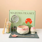 Ceramic matcha bowl set featuring a delicate cherry blossom design, complete with a bamboo whisk. The set showcases soft pink and white hues, perfect for 0