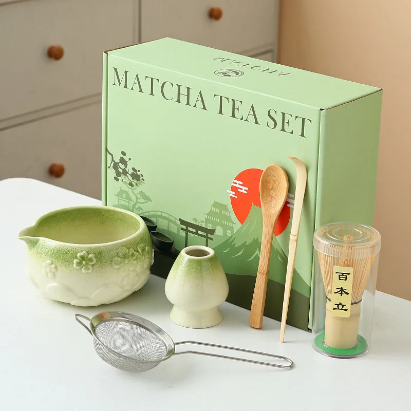 Ceramic matcha bowl set featuring a delicate cherry blossom design, complete with a bamboo whisk. The set showcases soft pink and white hues, perfect for 11