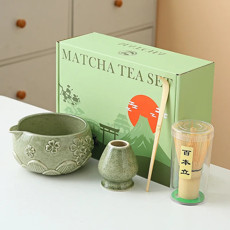 Ceramic matcha bowl set featuring a delicate cherry blossom design, complete with a bamboo whisk. The set showcases soft pink and white hues, perfect for 13