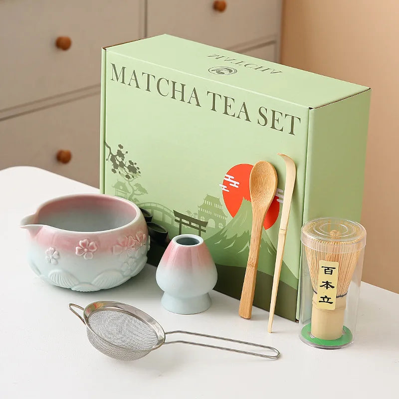 Ceramic matcha bowl set featuring a delicate cherry blossom design, complete with a bamboo whisk. The set showcases soft pink and white hues, perfect for 15