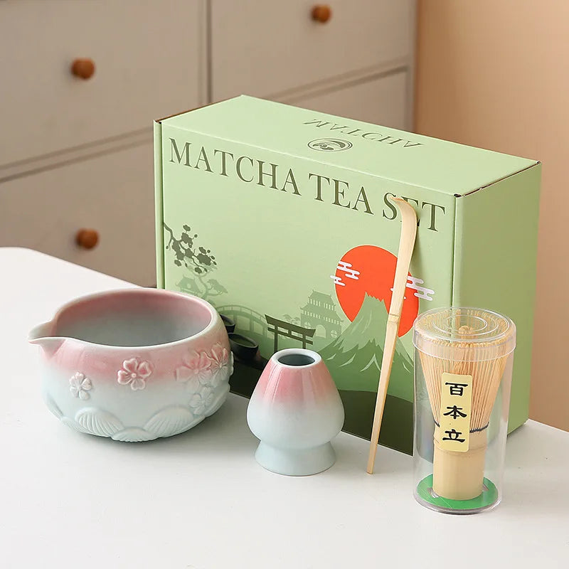 Ceramic matcha bowl set featuring a delicate cherry blossom design, complete with a bamboo whisk. The set showcases soft pink and white hues, perfect for 16