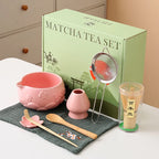 Ceramic matcha bowl set featuring a delicate cherry blossom design, complete with a bamboo whisk. The set showcases soft pink and white hues, perfect for 17
