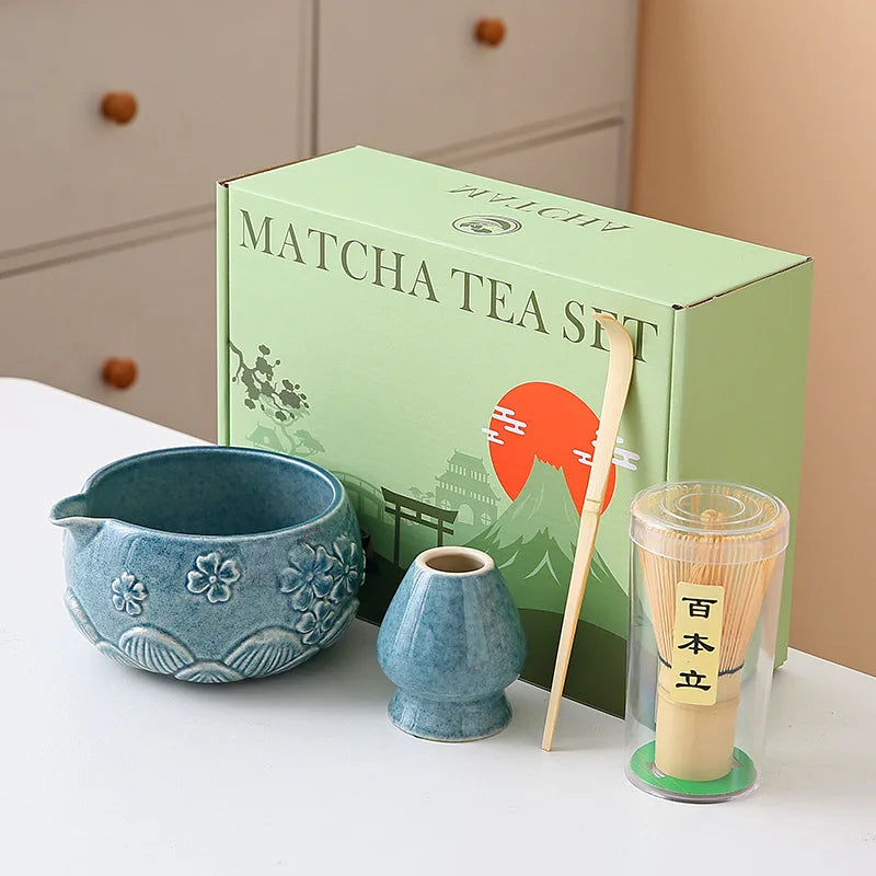 Ceramic matcha bowl set featuring a delicate cherry blossom design, complete with a bamboo whisk. The set showcases soft pink and white hues, perfect for 18