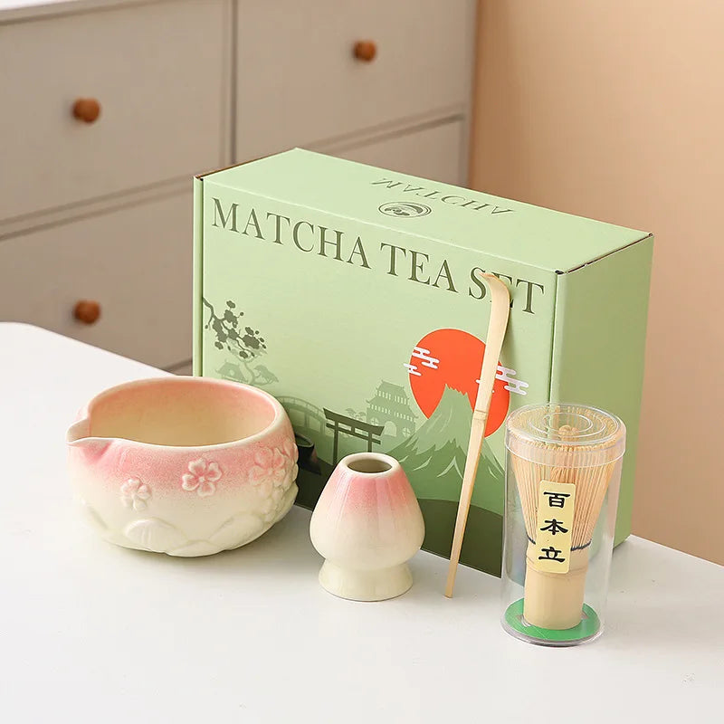 Ceramic matcha bowl set featuring a delicate cherry blossom design, complete with a bamboo whisk. The set showcases soft pink and white hues, perfect for 19