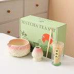 Ceramic matcha bowl set featuring a delicate cherry blossom design, complete with a bamboo whisk. The set showcases soft pink and white hues, perfect for 19