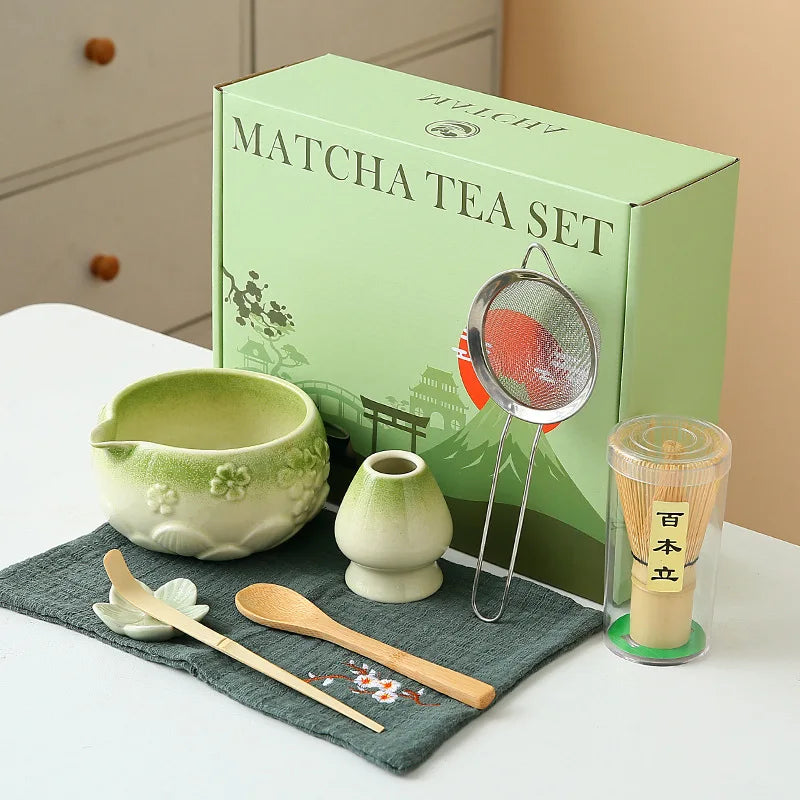Ceramic matcha bowl set featuring a delicate cherry blossom design, complete with a bamboo whisk. The set showcases soft pink and white hues, perfect for 20