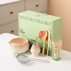 Ceramic matcha bowl set featuring a delicate cherry blossom design, complete with a bamboo whisk. The set showcases soft pink and white hues, perfect for 22