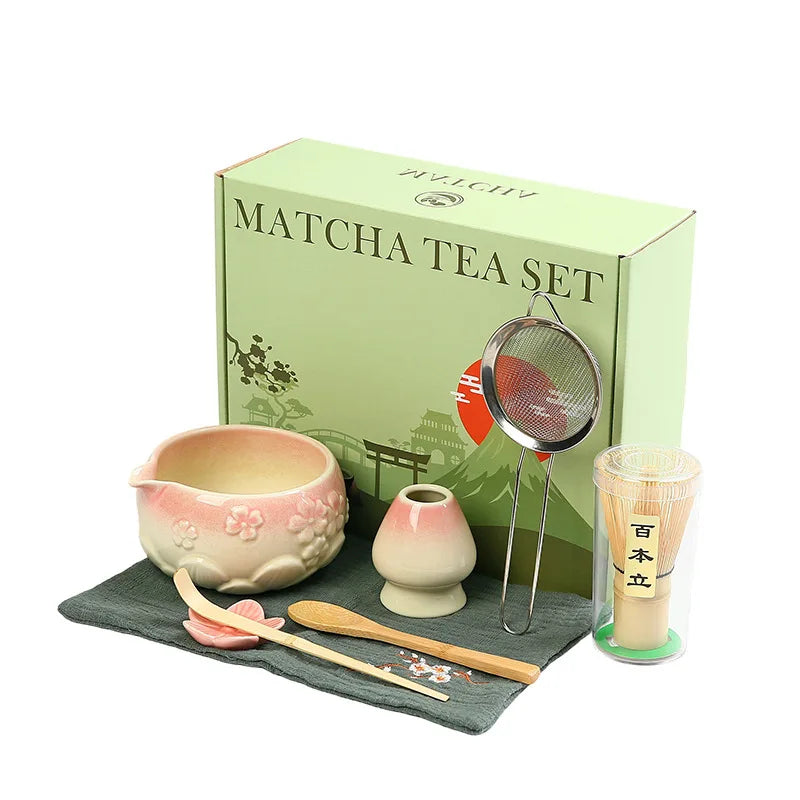 Ceramic matcha bowl set featuring a delicate cherry blossom design, complete with a bamboo whisk. The set showcases soft pink and white hues, perfect for 4