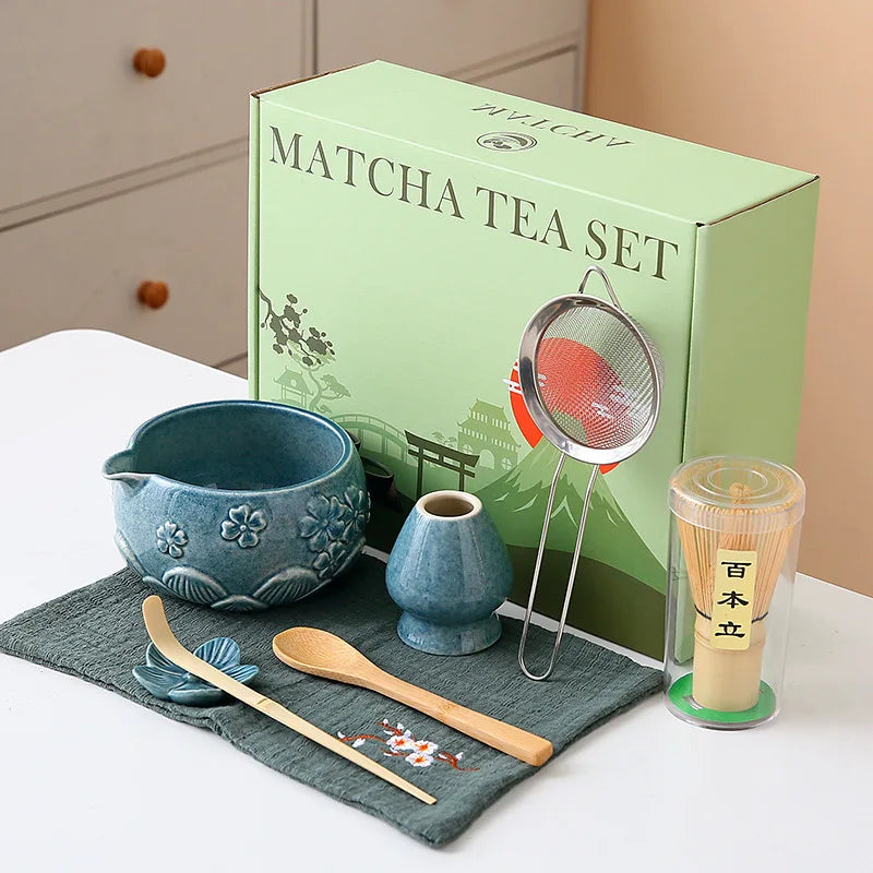 Ceramic matcha bowl set featuring a delicate cherry blossom design, complete with a bamboo whisk. The set showcases soft pink and white hues, perfect for 5
