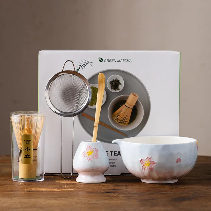 Elegant 5-piece ceramic matcha tea set featuring a delicate cherry blossom design. Includes a matcha bowl, whisk, scoop, and two cups. 0
