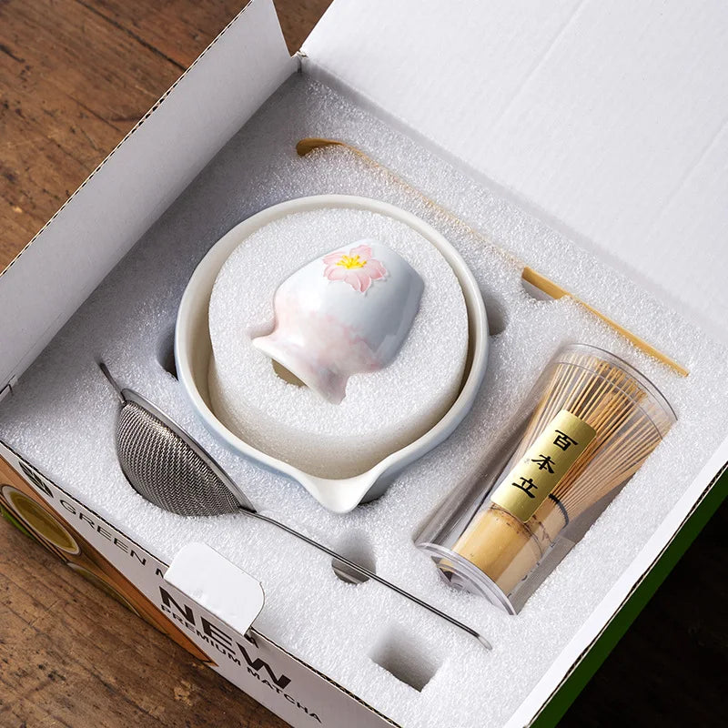 Elegant 5-piece ceramic matcha tea set featuring a delicate cherry blossom design. Includes a matcha bowl, whisk, scoop, and two cups. 2