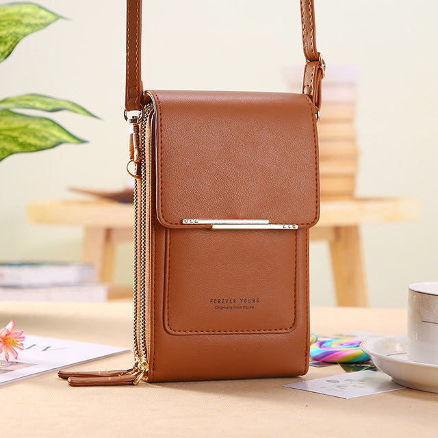 Compact crossbody phone bag in sleek black, crafted from durable faux leather. Features a spacious main compartment for your phone and an exterior card holder for easy 0