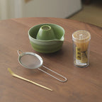 Compact Japanese matcha tea set featuring a stoneware bowl and bamboo whisk, perfect for preparing matcha. The earthy tones of the stoneware enhance the 5