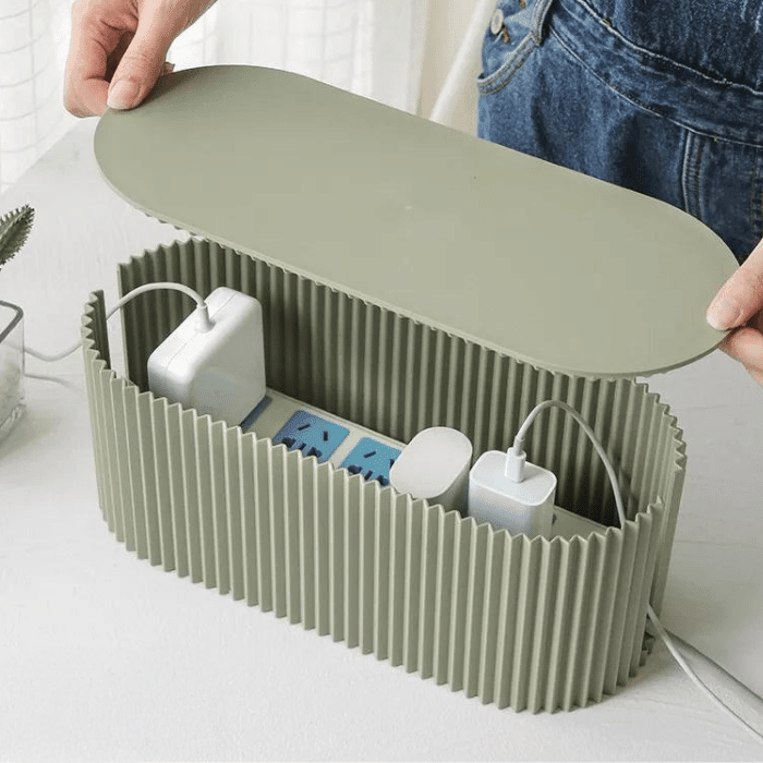 Green cable organizer with electronic devices on a white surface