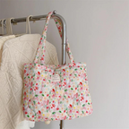 Floral quilted tote bag featuring a vibrant floral pattern, perfect for summer outings. Made from durable fabric with sturdy handles, ideal for carrying beach essentials 1