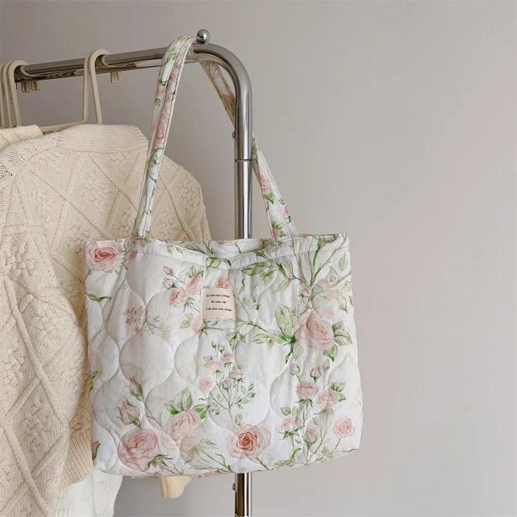 Floral quilted tote bag featuring vibrant summer flower patterns, perfect for beach outings. Made from durable, lightweight fabric with sturdy handles. Ideal for carrying 2