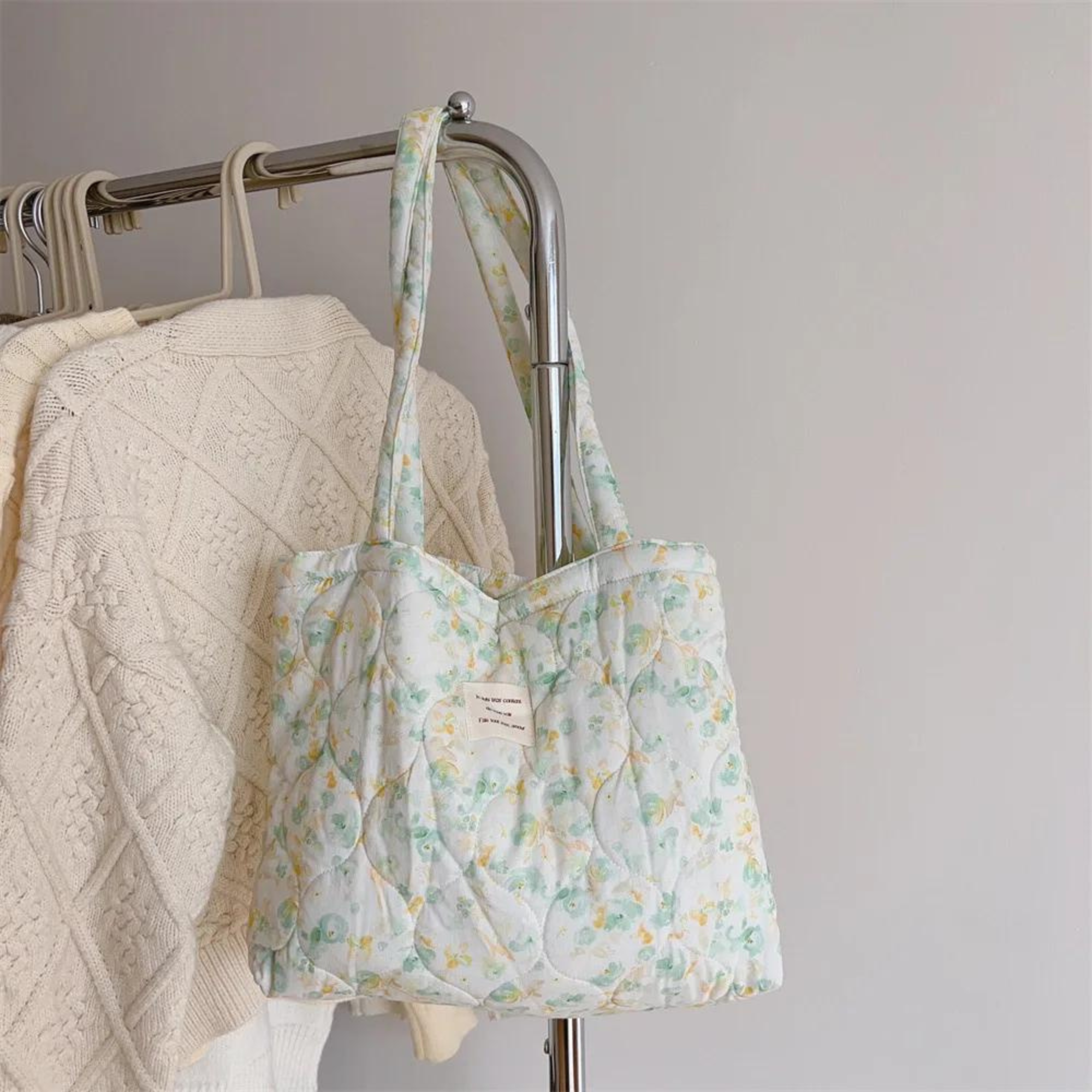 Floral quilted tote bag in vibrant colors, perfect for summer outings. Made from durable cotton, featuring a spacious interior and sturdy handles. Ideal for 3