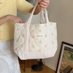 Stylish floral quilted tote bag featuring a vibrant flower pattern. Made from durable cotton fabric, it is perfect for beach outings or everyday errands. The 1