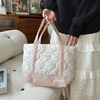 Floral quilted tote bag featuring a vibrant floral pattern, perfect for beach outings or daily use. Crafted from durable fabric with sturdy handles, this stylish 2