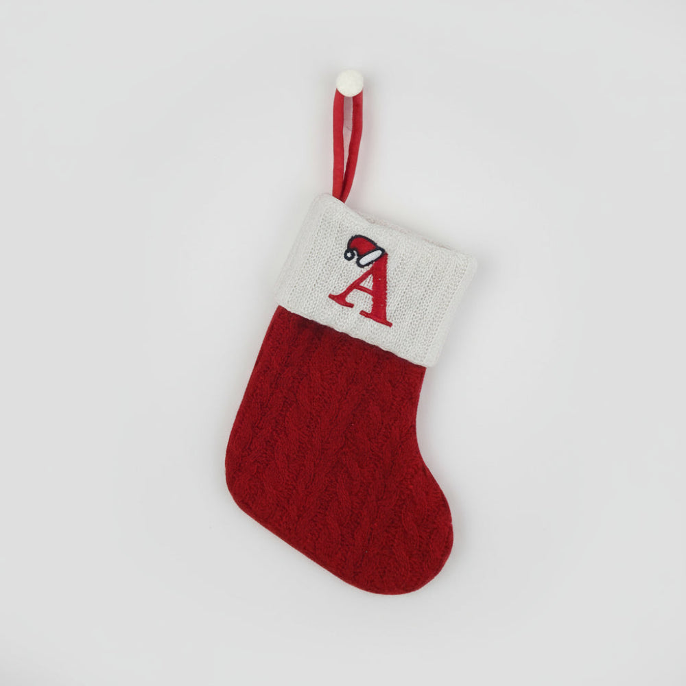 Knit monogram personalized Christmas stocking in festive red with white lettering. Classic knit texture adds warmth, perfect for holiday decor. Ideal for hanging by the 0