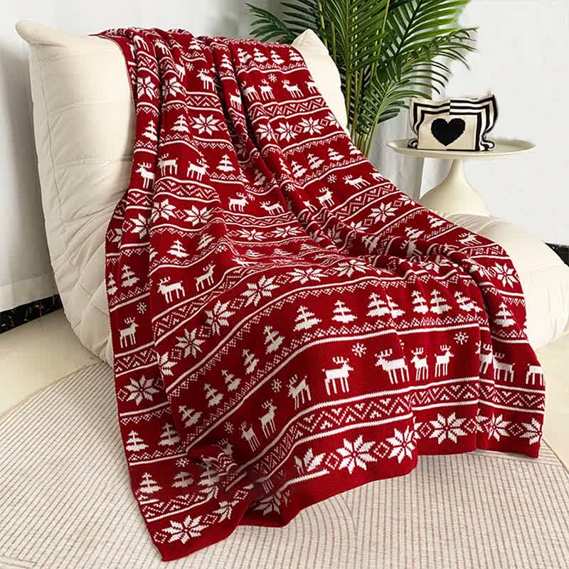 Cozy knitted throw blanket featuring a festive Christmas elk and snowflake design in red and white. Perfect for adding warmth and holiday cheer to your living space 1