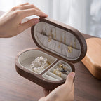 Oval mini wooden jewellery box featuring a rich mahogany finish and soft velvet lining, perfect for organizing rings and earrings. Its compact design adds elegance to any 1