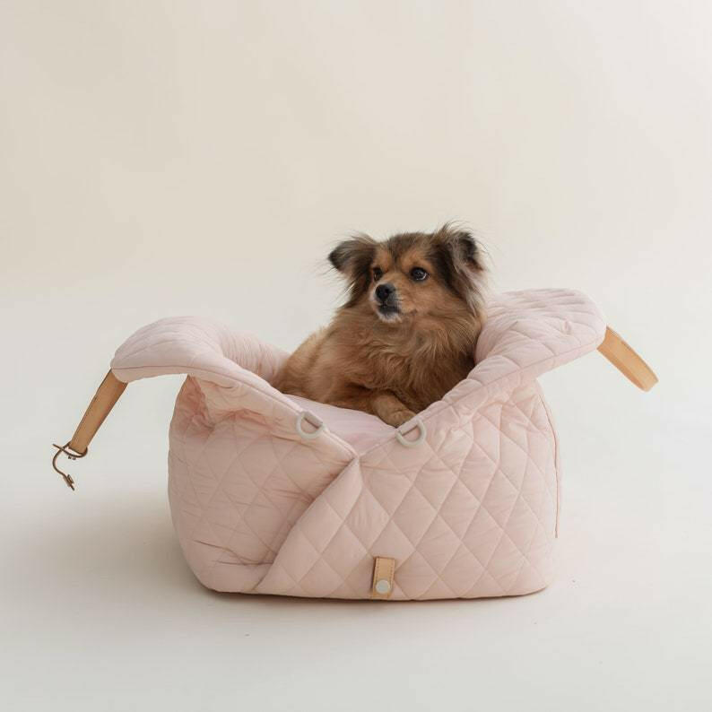 Beige quilted fabric pet carrier that doubles as a car seat. Features sturdy construction and comfortable interior, measuring 17.3 x 13. 4