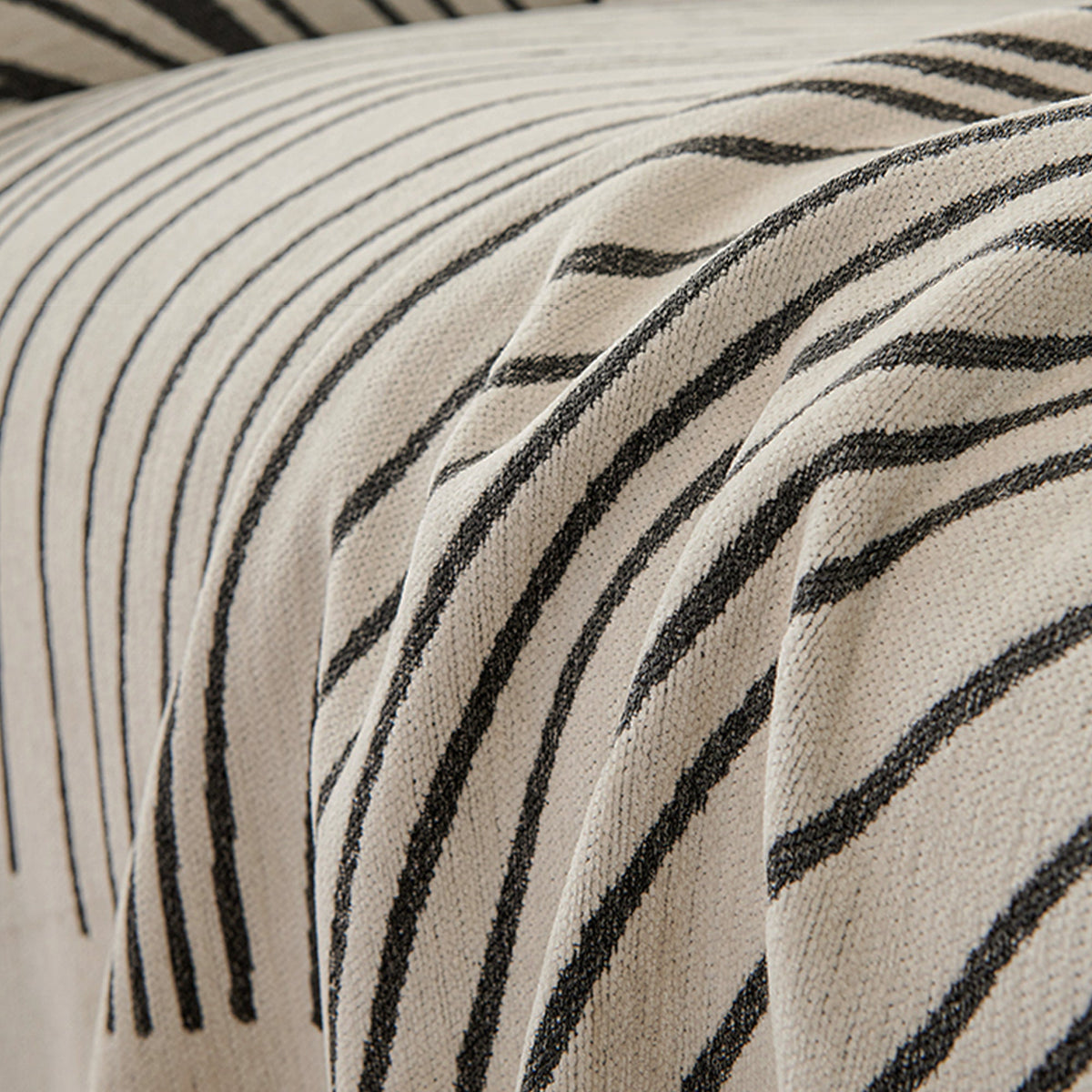 Reversible jacquard sofa cover in soft gray and cream, featuring an intricate woven pattern. Made from durable, pet-friendly fabric, it effortlessly protects 4