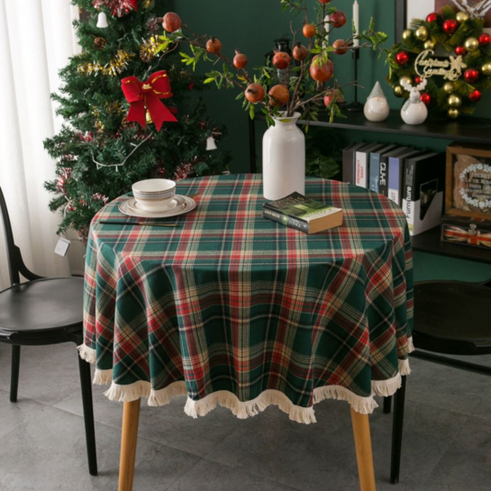 Round tablecloth featuring a vintage holiday plaid pattern in red, green, and white, adorned with decorative tassels. Made from durable fabric, perfect for 0