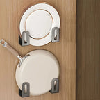 Set of two wall-mounted kitchen racks in sleek black metal, designed for multifunctional storage. Ideal for holding cutting boards and pot covers, also suitable as 4