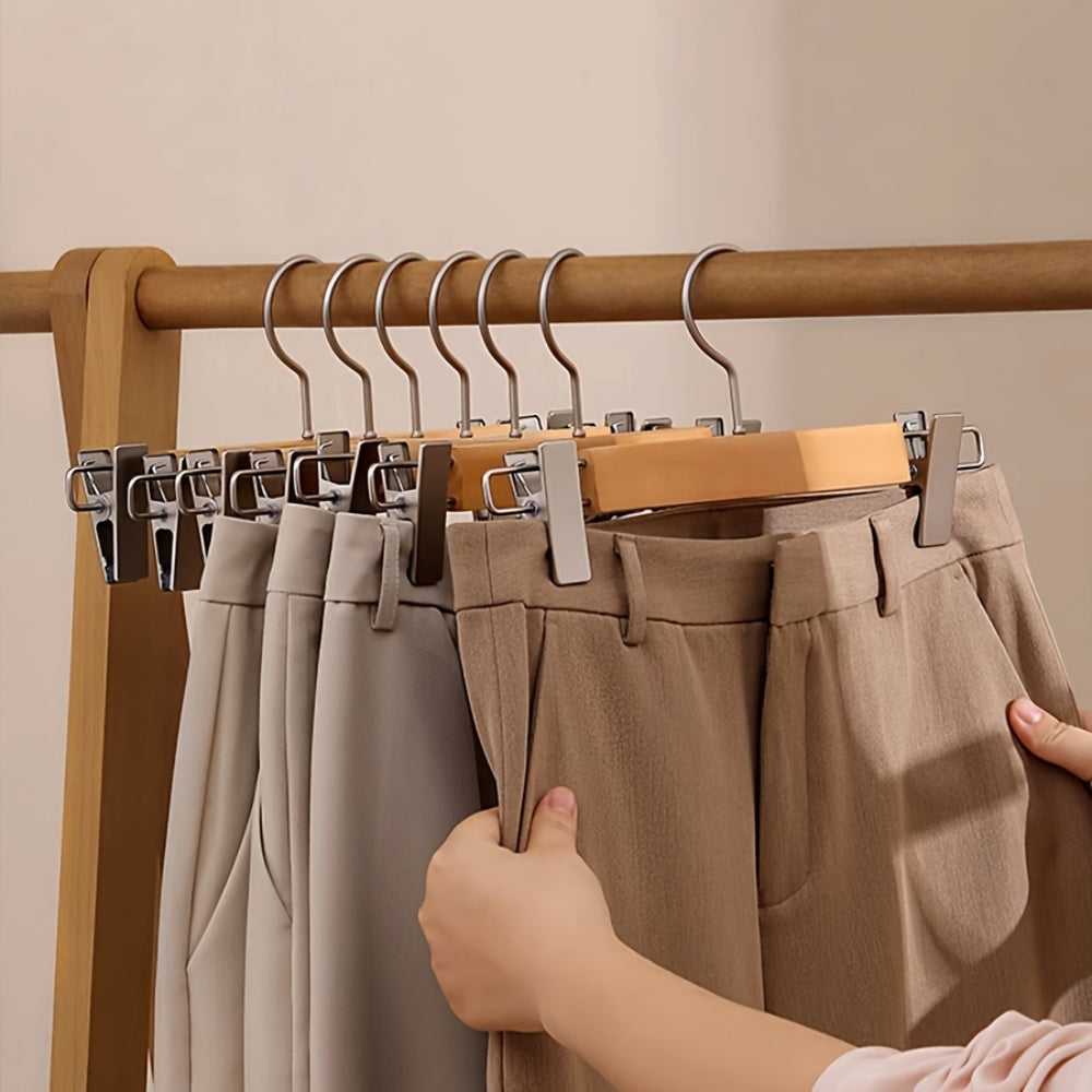 Set of wooden pants hangers with silver clips, designed for closet organization. Made from durable natural wood with a smooth finish, featuring a classic design. 6