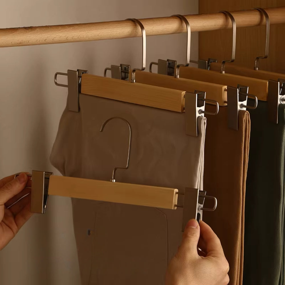 Set of wooden pants hangers with adjustable clips for secure trouser storage. Features a natural wood finish with a smooth surface, designed for closet organization. 7