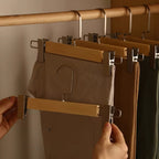 Set of wooden pants hangers with adjustable clips for secure trouser storage. Features a natural wood finish with a smooth surface, designed for closet organization. 7