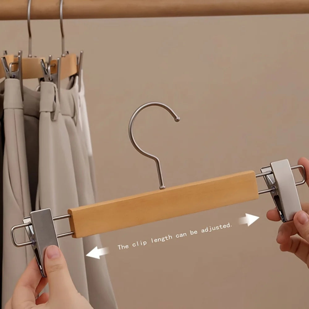 Set of wooden pants hangers with adjustable clips, designed for closet organization. Features a natural wood finish with a sleek design, perfect for keeping trousers neatly 8