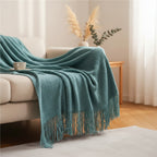 Dear Hazel teal knit blanket with fringe, Scandinavian design, soft yarn, perfect for indoor/outdoor comfort.
